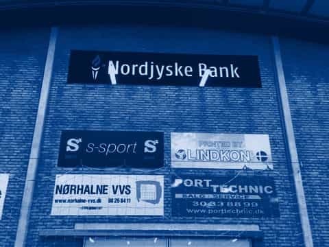Sponsorskilte på væggen i en idrætshal