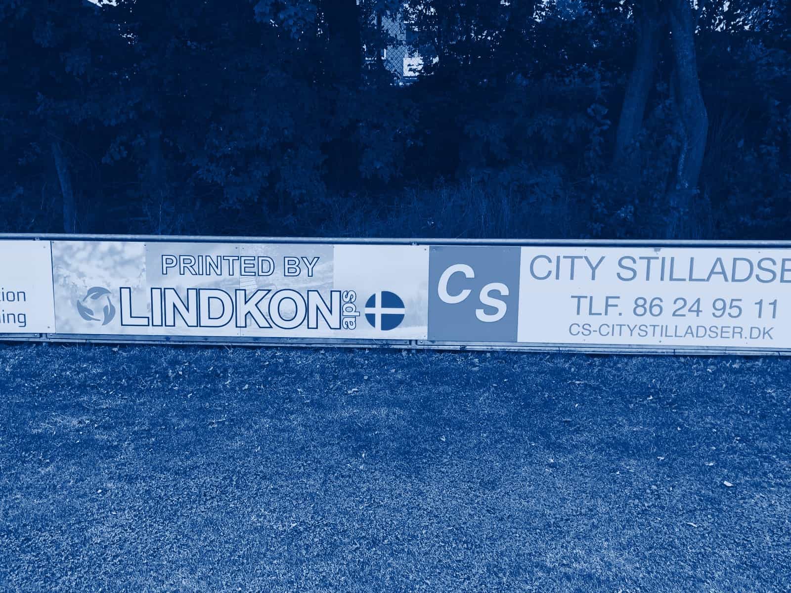 Sponsorplader på rækværket langs en fodboldbane